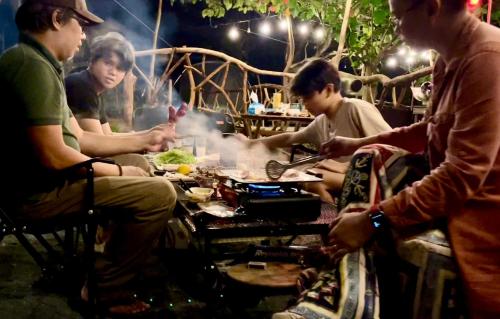 a group of people sitting around a table eating food at Windfarm Nature Escape in Pililla