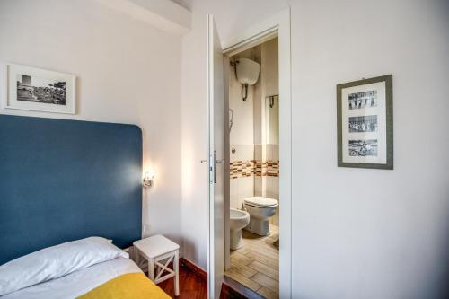 a bedroom with a blue bed and a bathroom at Circus Maximus B&B in Rome