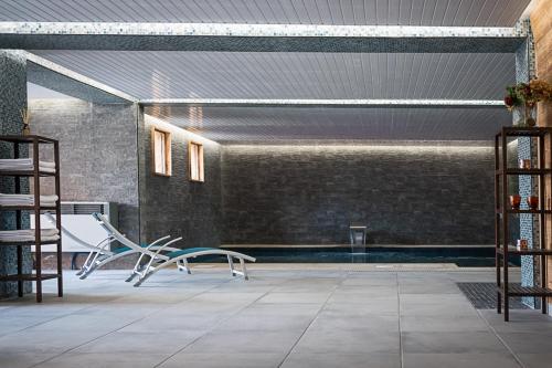 um quarto com uma piscina com um banco e uma mesa em Black Diamond Lodge em Sainte-Foy-Tarentaise