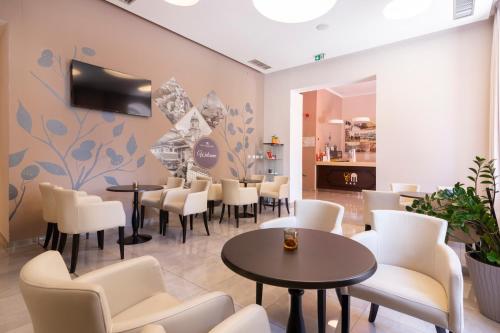 a restaurant with tables and chairs in a room at Hotel Continental in Rijeka