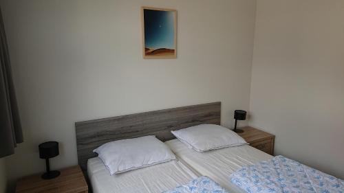 - une chambre avec un lit et une photo sur le mur dans l'établissement Cube IJsselzicht, à Lathum