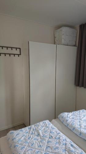 a bedroom with two white closets and a bed at Cube IJsselzicht in Lathum