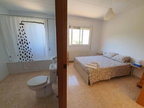 1 dormitorio con 1 cama y baño con aseo en Alberg Ca La Jepa, en Prat de Comte