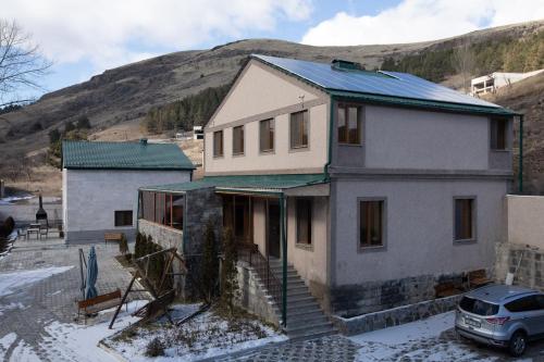 a house with a blue roof on top of it at Alaska Resort in Tsaghkadzor