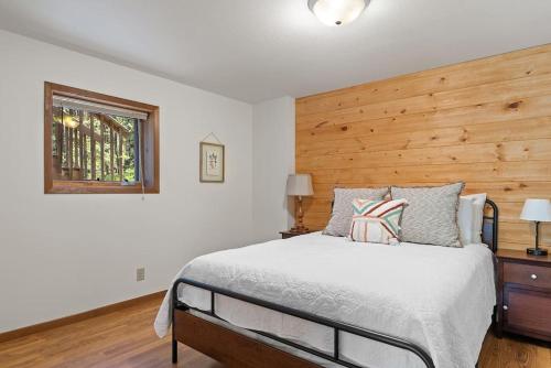 a bedroom with a bed and a wooden wall at Nature Stay with Views Like No Where Else in Custer