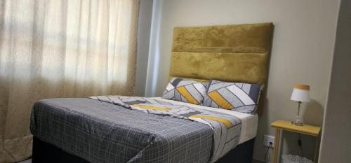 a bedroom with a bed and a window at Tere's place: Tulip Luxury apartment in Midrand