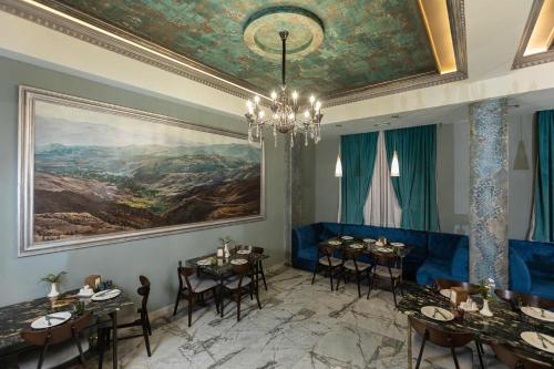 a dining room with tables and a painting on the wall at Alaska Resort in Tsaghkadzor