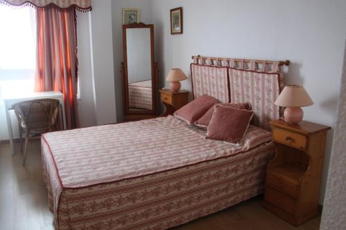 a bedroom with a bed with a dresser and a mirror at Apartamentos Nautilus in Bajamar