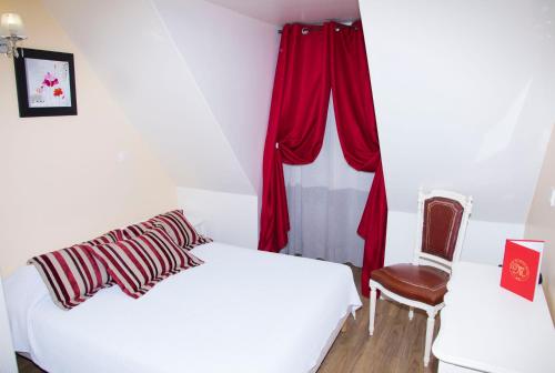 a bedroom with a white bed with red curtains and a chair at Hôtel du Mont Blanc in Paris