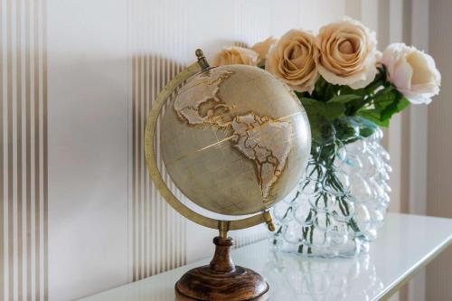 a globe on a table next to a vase of roses at Best Western Malmia Hotel in Skellefteå