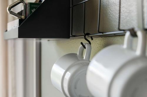 two cups hanging on a wall with a camera at Best Western Malmia Hotel in Skellefteå