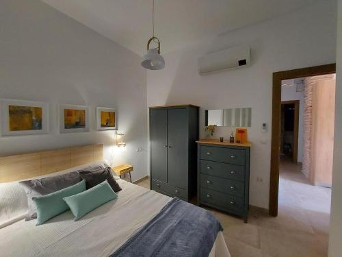 a bedroom with a bed and a dresser in it at Casa Rural Eralta in Dúrcal