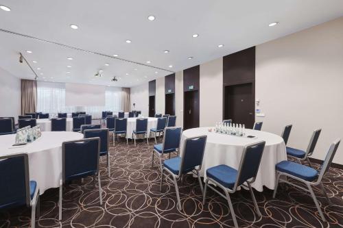 a conference room with white tables and blue chairs at Radisson Blu Sobieski in Warsaw