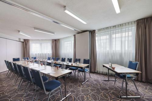 a conference room with long tables and blue chairs at Radisson Blu Sobieski in Warsaw