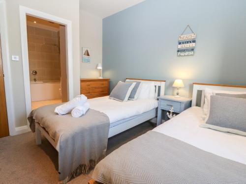 a bedroom with two beds with towels on top of them at Sandy House in Rhosneigr