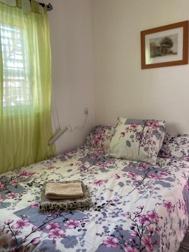 a bedroom with a bed with a floral comforter at Rahel’s Home in Beer Sheva