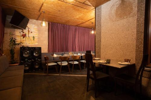 a dining room with tables and chairs and a red curtain at Alaska Resort in Tsaghkadzor