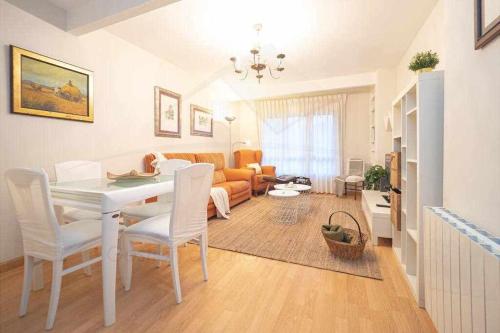 een woonkamer met een witte tafel en stoelen bij Brizal Apartamento in Gijón