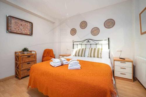 een slaapkamer met een bed met twee handdoeken erop bij Brizal Apartamento in Gijón