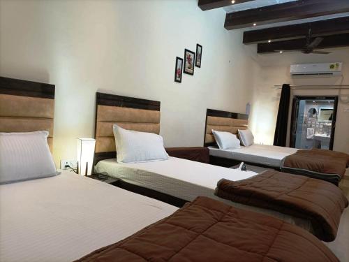 a group of three beds in a room at Foreigners Inn in Varanasi
