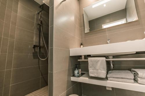 a bathroom with a shower and a mirror and towels at Chambres d'Hôtes de l'Avel Vor in Port-Louis