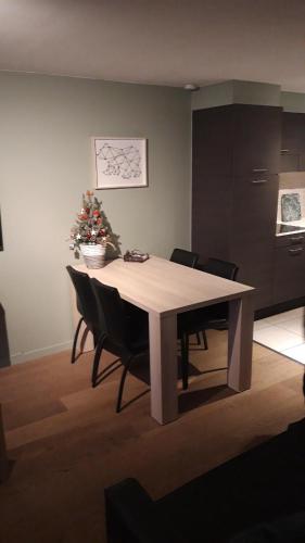 a dining room table with chairs and a christmas tree at Terrasses de Malmedy - Duplex 455 in Malmedy