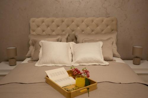 a bed with a tray with a book on it at Apartman SUNSET in Sremska Mitrovica