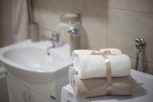 una pila de toallas sentadas en una mesa en un baño en Apartman SUNSET en Sremska Mitrovica