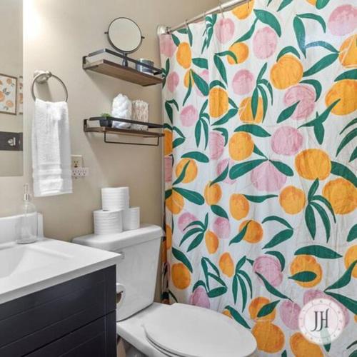 a bathroom with a toilet and a shower curtain with oranges at Pet Friendly Large Fenced Backyard Covered Patio in Rapid City