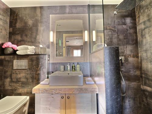 uma casa de banho com um lavatório, um espelho e um chuveiro em Chalet Les Gets, 7 pièces, 12 personnes - FR-1-627-6 em Les Gets