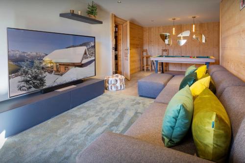 a living room with a couch and a tv at Chocolat Manigod - OVO Network in Manigod
