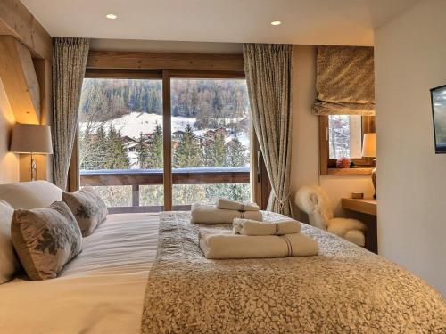 a bedroom with a large bed with a large window at Chalet Morzine, 7 pièces, 12 personnes - FR-1-627-20 in Morzine