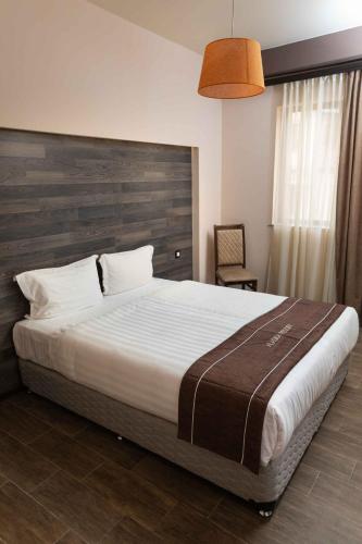 a bedroom with a large bed with a wooden headboard at Alaska Resort in Tsaghkadzor