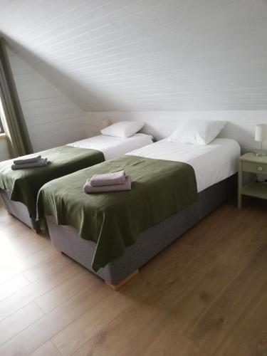 two beds sitting next to each other in a room at Kaptenite Kodu in Kuri