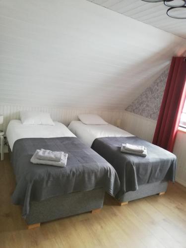 2 Betten in einem Zimmer mit Dachgeschoss in der Unterkunft Kaptenite Kodu in Kuri