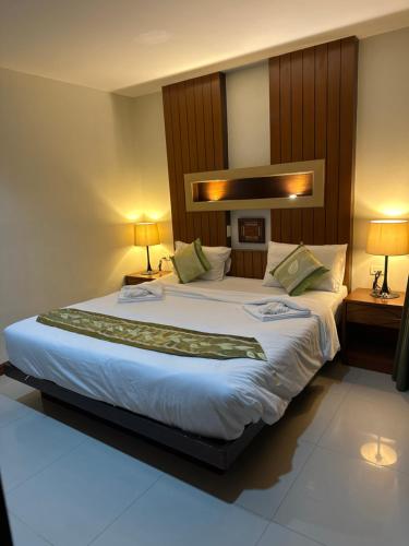 a large bed in a hotel room with two lamps at The Prisha inn in Patong Beach