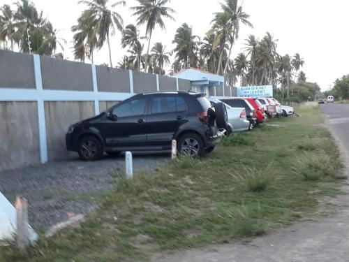 a row of cars parked next to a fence at Casas e kitnetes em Praia de Guaibim in São Fidélis