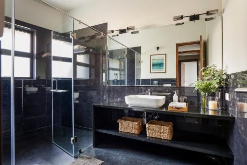 a bathroom with a sink and a glass shower at SaffronStays Ahilya Waters by Kosha Villas, Pawna - pool villa with panoramic view of Pawna Lake in Āmbavna