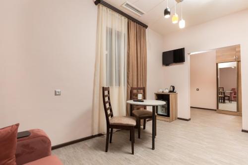 a living room with a table and chairs and a television at Alaska Resort in Tsaghkadzor