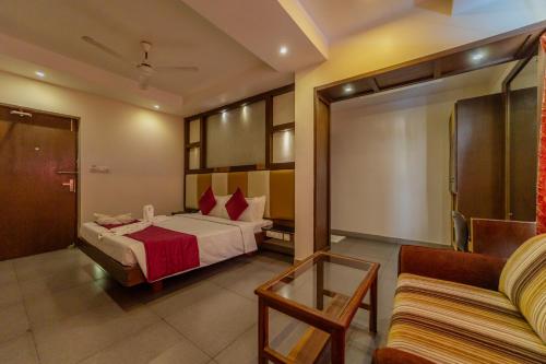 um quarto de hotel com uma cama e um sofá em Hotel Tamizh Park em Pondicherry