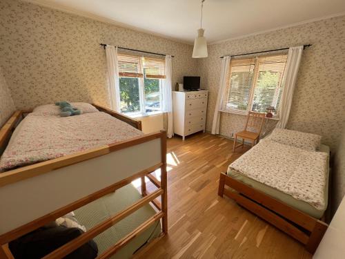 sypialnia z 2 łóżkami piętrowymi i 2 oknami w obiekcie typical Swedish cosy holiday house in Målilla, Småland w mieście Målilla