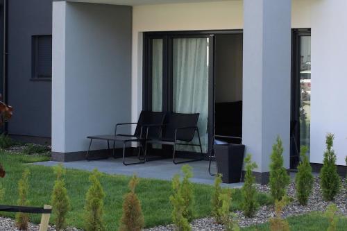 a patio with two chairs and a television on a building at Apartament Niechorze in Niechorze