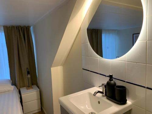 een badkamer met een wastafel en een spiegel bij RB Hostel in Zierikzee