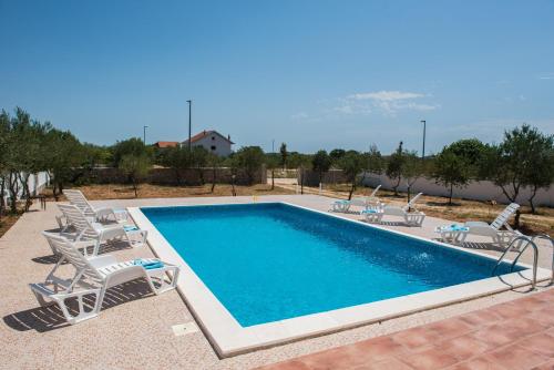 a swimming pool with lounge chairs and a pool at Vila CROATIA in Velika Čista