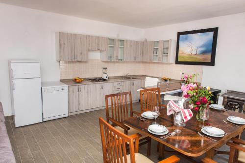 a kitchen with a wooden table with chairs and a dining room at Vila CROATIA in Velika Čista