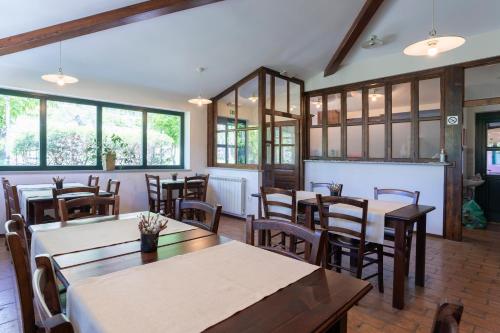 a dining room with tables and chairs and windows at Guest House Valentincic in Nova Gorica