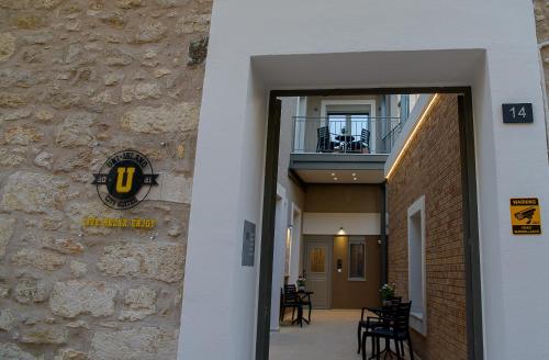 wejście do budynku z znakiem na boku budynku w obiekcie Uni Island - City Center Suites w Heraklionie