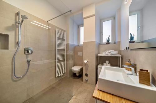 a bathroom with a sink and a shower and a toilet at Central Suite Meran in Merano