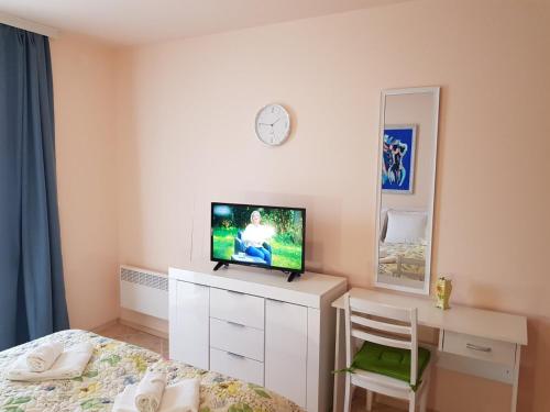 1 dormitorio con 1 cama, TV y escritorio en Панорама Стойките Релакс, en Stoykite