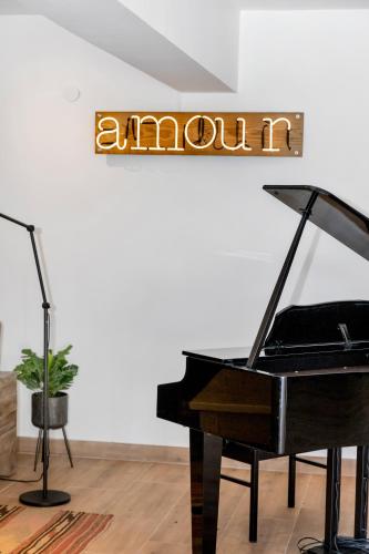 a piano in a room with a sign that reads amoudi at Boutique Hotel Wanapa - Adult Friendly - 14 years and older in Kralendijk